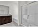 Bright bathroom featuring a glass-enclosed shower, soaking tub, and vanity with granite countertop at 7622 Oakmoss Loop, Davenport, FL 33837