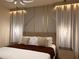 Bedroom featuring stylish lighting, decorative wall, and a well made king bed at 7622 Oakmoss Loop, Davenport, FL 33837