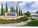 Attractive community entrance sign with lush landscaping, manicured lawns, and a welcoming pathway at 7622 Oakmoss Loop, Davenport, FL 33837