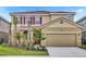 Charming two-story home featuring a well-manicured lawn, beautiful landscaping, and a two-car garage at 7622 Oakmoss Loop, Davenport, FL 33837