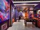The themed game room has custom designs, a foosball table, and vibrant lighting, creating a fun and immersive entertainment space at 7622 Oakmoss Loop, Davenport, FL 33837