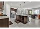 Modern kitchen with stainless steel appliances, granite countertops, an island with seating, and dark wood cabinetry at 7622 Oakmoss Loop, Davenport, FL 33837