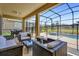 Relaxing screened lanai features outdoor furniture and a view of the pool and backyard at 7622 Oakmoss Loop, Davenport, FL 33837