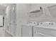 Functional laundry room featuring modern appliances, shelving, and ample storage space at 7622 Oakmoss Loop, Davenport, FL 33837
