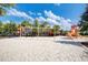 Community playground featuring swings, a slide, and other play equipment, all set in a sandy area at 7622 Oakmoss Loop, Davenport, FL 33837