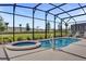 Beautiful in-ground pool and hot tub with screened enclosure overlooks manicured green space at 7622 Oakmoss Loop, Davenport, FL 33837