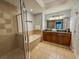 The spacious bathroom features a soaking tub, walk-in shower, and a double vanity with granite countertops at 7650 Whisper Way # 102, Reunion, FL 34747