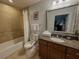 The bathroom showcases a granite countertop, ornate mirror, and tiled shower with tub at 7650 Whisper Way # 102, Reunion, FL 34747