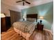 This bedroom boasts wood floors, a ceiling fan, and a calming light-blue accent wall at 7650 Whisper Way # 102, Reunion, FL 34747