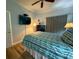 This bedroom features wood floors, neutral curtains, and a flatscreen TV mounted on the wall at 7650 Whisper Way # 102, Reunion, FL 34747