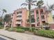 Elegant three-story building features private balconies, lush landscaping, and inviting curb appeal at 7650 Whisper Way # 102, Reunion, FL 34747