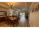 Open-concept living and dining area with wood floors and natural light from sliding doors to backyard at 7650 Whisper Way # 102, Reunion, FL 34747