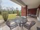 The patio area includes an outdoor table with chairs and a lounge chair overlooking the greenery at 7650 Whisper Way # 102, Reunion, FL 34747