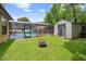 Backyard featuring a screened-in pool, storage shed, well maintained lawn, and fire pit at 7846 Snowberry Cir, Orlando, FL 32819