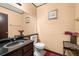 Stylish bathroom features a granite countertop, decorative mirror, and a toilet with tiled flooring at 7846 Snowberry Cir, Orlando, FL 32819