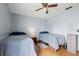 Bright bedroom with two twin beds, ceiling fan, and laminate wood flooring at 7846 Snowberry Cir, Orlando, FL 32819