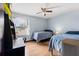 Well-lit bedroom with two beds, a ceiling fan, a desk, and natural light at 7846 Snowberry Cir, Orlando, FL 32819