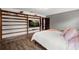Spacious bedroom features hardwood flooring, custom built-in shelving and a large wall-mounted television at 7846 Snowberry Cir, Orlando, FL 32819