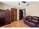 Bedroom with hardwood floors, large closet and comfortable brown sofa at 7846 Snowberry Cir, Orlando, FL 32819