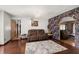 Comfortable living room with a large sofa, decorative wallpaper, and a hardwood floor with an area rug at 7846 Snowberry Cir, Orlando, FL 32819