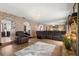 Open-concept living room with a brick accent wall, mirrored wall, hardwood floors, and comfortable seating at 7846 Snowberry Cir, Orlando, FL 32819
