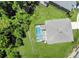 Aerial view of a private screened-in pool with a patio, surrounded by a lush green yard and mature trees at 8491 Oasis Key Cv, Kissimmee, FL 34747