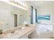 Bright bathroom with a tub, vanity with ample counter space, and a large mirror at 8491 Oasis Key Cv, Kissimmee, FL 34747