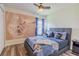 Themed bedroom with wood-look flooring, a large mural on the wall, and neutral decor at 8491 Oasis Key Cv, Kissimmee, FL 34747