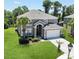 Stunning two-story home with lush landscaping, a two-car garage, mature trees, and a manicured lawn at 8491 Oasis Key Cv, Kissimmee, FL 34747
