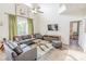 Spacious living room with green accents, wood-look flooring, and large windows with a serene backyard view at 8491 Oasis Key Cv, Kissimmee, FL 34747