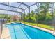 Private screened-in pool with a jacuzzi, surrounded by lush landscaping and mature trees at 8491 Oasis Key Cv, Kissimmee, FL 34747