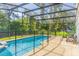 Private screened-in pool with safety fence and a spacious patio, surrounded by mature trees at 8491 Oasis Key Cv, Kissimmee, FL 34747