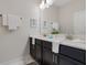 Well-lit bathroom featuring a double sink vanity with dark wood cabinets and white countertops at 8947 Stinger Dr, Davenport, FL 33896