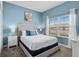 Bedroom with a queen-sized bed, a window view, and contemporary decor at 8947 Stinger Dr, Davenport, FL 33896