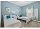 Comfortable bedroom with two twin beds, blue accent pillows, and bright natural light at 8947 Stinger Dr, Davenport, FL 33896