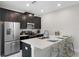 Stylish kitchen with black cabinetry, stainless steel appliances, and marble flooring at 8947 Stinger Dr, Davenport, FL 33896