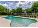Lush backyard featuring a private pool surrounded by green foliage and a wooden fence at 1016 Ohanlon Ct, Oviedo, FL 32765