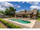 Beautiful backyard with a sparkling pool, spacious patio, and lush landscaping under a sunny sky at 1016 Ohanlon Ct, Oviedo, FL 32765
