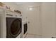 Bright laundry room with washer, dryer and ample storage space next to a closed door at 1016 Ohanlon Ct, Oviedo, FL 32765