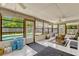 Well-lit sunroom with tiled floor, ceiling fans, large windows, and comfortable wicker seating at 1016 Ohanlon Ct, Oviedo, FL 32765