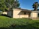 Backyard view of the home features a covered patio, a brown roof, and green grass at 1203 Atlantic Ct, Kissimmee, FL 34759