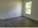This cozy bedroom has a large window for natural light and wood-look laminate flooring at 1203 Atlantic Ct, Kissimmee, FL 34759
