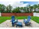 Serene backyard patio with blue Adirondack chairs and lush green lawn surrounded by trees at 1659 Sage Creek Ct, Orlando, FL 32824