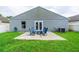 Expansive backyard with a patio seating area, lush lawn, and privacy fencing at 1659 Sage Creek Ct, Orlando, FL 32824