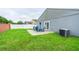 Lush backyard with a patio seating area, green lawn, and a privacy fence at 1659 Sage Creek Ct, Orlando, FL 32824