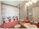 Bright bathroom featuring a Mickey Mouse shower curtain and vanity with red accents at 1659 Sage Creek Ct, Orlando, FL 32824