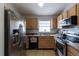 Well-equipped kitchen with stainless steel refrigerator, oak cabinets, and modern appliances at 1659 Sage Creek Ct, Orlando, FL 32824