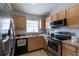 Well-equipped kitchen featuring stainless steel appliances, oak cabinets, and tile flooring at 1659 Sage Creek Ct, Orlando, FL 32824