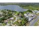 An aerial perspective of a community featuring homes, commercial buildings, a lake, and roadways at 166 Paradise Island Dr, Haines City, FL 33844
