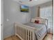 This cozy bedroom offers tile flooring, light gray walls, and a decorative white wood bed frame at 166 Paradise Island Dr, Haines City, FL 33844